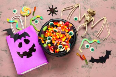 Lezzetli şekerlerle beste, Cadılar Bayramı süslemeleri ve grunge arkaplanda alışveriş çantası