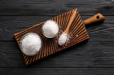 Koyu ahşap arka planda deniz tuzu kaseleri olan tahta.