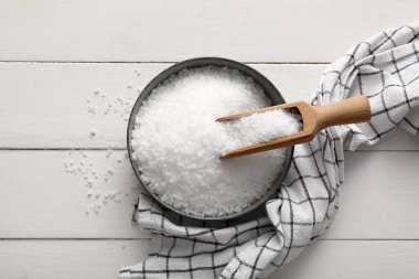 Hafif ahşap zemin üzerinde deniz tuzu ve peçete ile kase