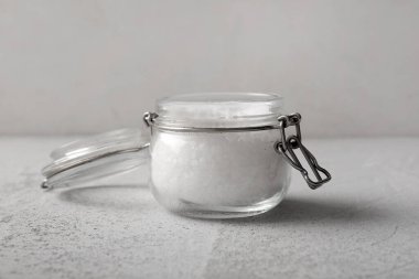 Arkaplanda deniz tuzu olan cam kavanoz.