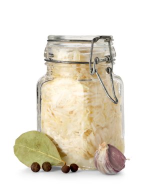 Lezzetli lahana turşulu kavanoz ve beyaz arka planda farklı baharatlar.