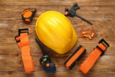 Sert şapka, radyo vericisi ve ahşap arka planda emniyet kemerleri.