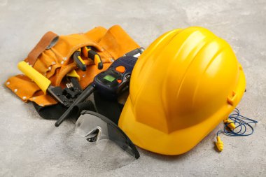 Gri grunge arka planında radyo vericisi ve güvenlik ekipmanına sahip sert şapka