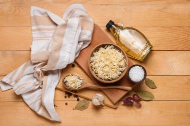 Lezzetli lahana turşulu kase ve ahşap arka planda farklı baharatlar.