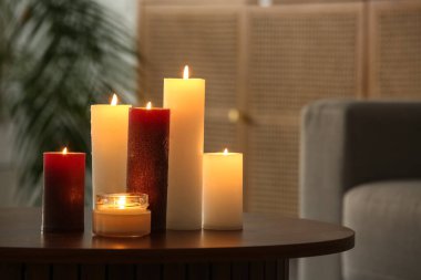 Oturma odasındaki ahşap masada mum yakmak, yakın çekim.