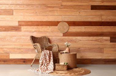 Hasır koltuğu ve kahve masasında suni çiçekleri olan şık bir oturma odası.