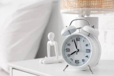 Alarm saati, lamba ve biblo açık yatak odasında, yakın plan.