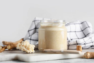 Mermer tepsi, peçete, cam kavanoz ve turp soslu kaşık mavi grunge arkaplan, yakın çekim