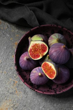 Arka planda taze olgun incirlerle dolu bir kase.