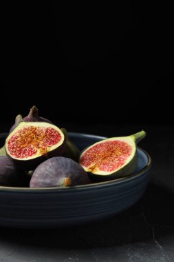 Siyah masanın üstünde taze incir kasesi.