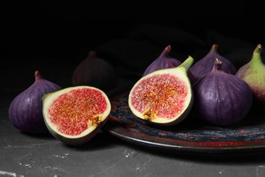 Siyah masanın üstünde taze incir tabağı.