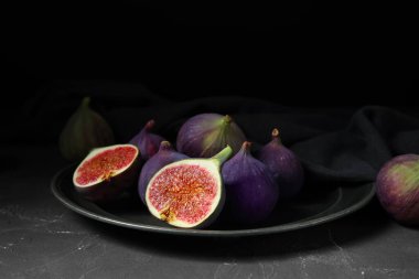 Siyah masanın üstünde taze incir tabağı.