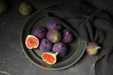 Siyah arka planda taze taze incir tabağı