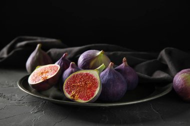 Siyah masanın üstünde taze incir tabağı.