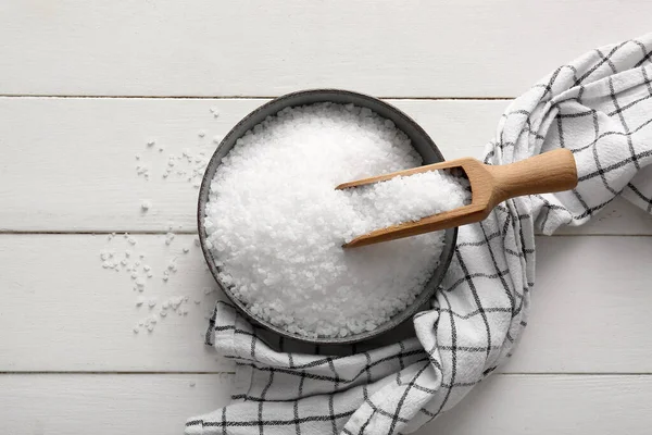 Hafif ahşap zemin üzerinde deniz tuzu ve peçete ile kase