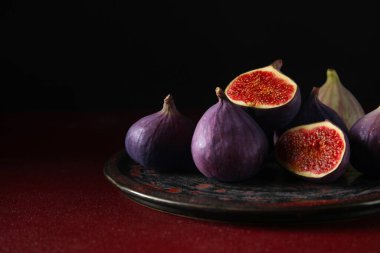 Kırmızı masada taze incir tabağı.