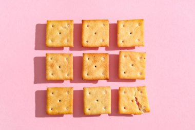 Pembe arka planda lezzetli krakerleri olan kompozisyon, yakın plan.