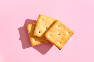 Pembe arka planda lezzetli krakerleri olan kompozisyon, yakın plan.