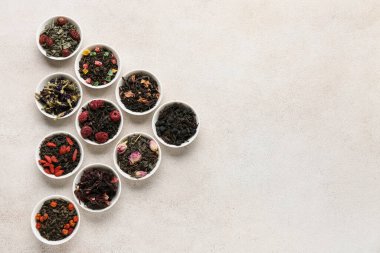 Hafif arkaplanda farklı meyve çayları olan kaseler