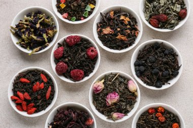 Hafif arkaplanda farklı meyve çayları olan kaseler