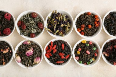 Hafif arkaplanda farklı meyve çayları olan kaseler