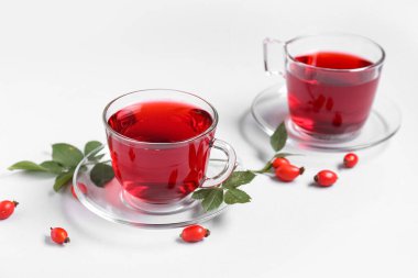 Gri arkaplanda sıcak gül çayı ve böğürtlen bardakları