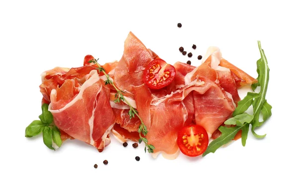 Lezzetli prosciutto dilimleri kekik, roka, biber ve beyaz arka planda vişneli domates.