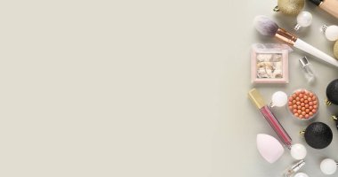 Gri arka planda Noel topları ve dekoratif kozmetik ürünleri olan güzel bir kompozisyon