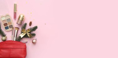 Pembe zemin üzerine noel süslemeleri ve kozmetik ürünleri metin ve üst görünüm için boşluk