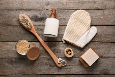 Masaj fırçası, eldiven, sabun ve ahşap zemin üzerinde deniz tuzu olan kase.