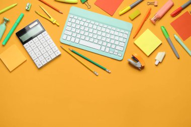 Modern bilgisayar klavyesine sahip kompozisyon ve turuncu arka planda farklı kırtasiye