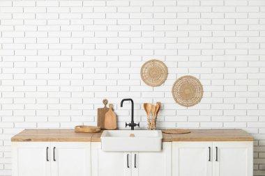 Beyaz tezgahlı, çatallı ve lavabolu şık bir mutfak.