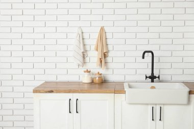 Beyaz tezgahlı ve lavabolu şık bir mutfak.