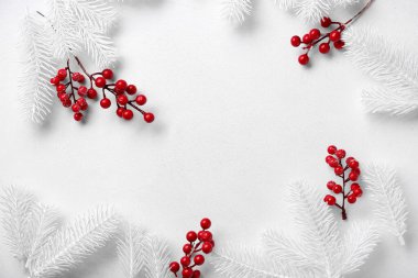 Yapay köknar dallarından ve beyaz arka planda böğürtlenlerden yapılmış çerçeve, yakın plan