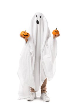 Cadılar Bayramı 'nda hayalet gibi giyinmiş beyaz arka planda balkabakları olan küçük bir çocuk.