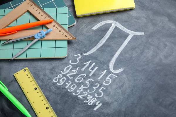 Номер Пи написан на черной доске с ноутбуками и канцелярскими принадлежностями