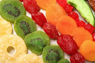 Gri arka planda farklı şekerli meyveler, yakın plan