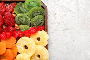 Farklı meyveli tepsi ve gri arka planda fıstık.