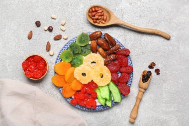 Farklı meyveli ve fındıklı tabaklar gri arka planda