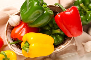 Taze dolmalık biberli ve beyaz ahşap arka planda sarımsaklı bir hasır kase.