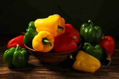 Tahta arka planda taze dolmalık biberli kase.