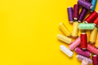 Sarı arkaplanda renkli iplik makaraları
