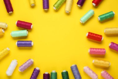 Sarı arkaplanda renkli iplik makaralarından yapılmış çerçeve