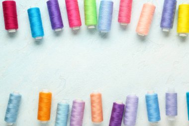 Açık mavi arkaplanda renkli iplik havuzlarından yapılmış çerçeve