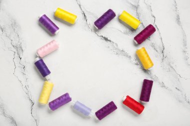 Mermer zemin üzerinde renkli iplik makaralarından yapılmış çerçeve