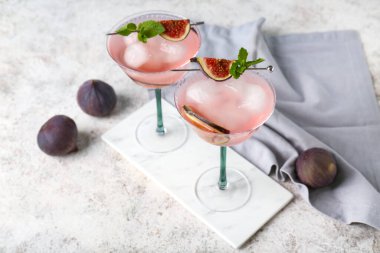 Lezzetli incirli limonata, nane ve beyaz arka planda meyveler.