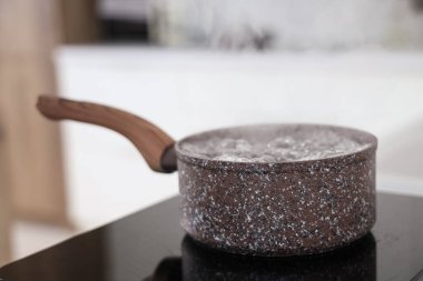 Mutfaktaki mini fırında kaynar su ile tencere, yakın plan.