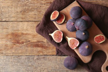 Tahta kesme tahtası Tahta arka planda taze olgun incirlerle