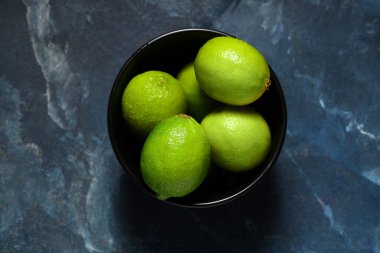 Mavi arka planda taze limonlu kase.