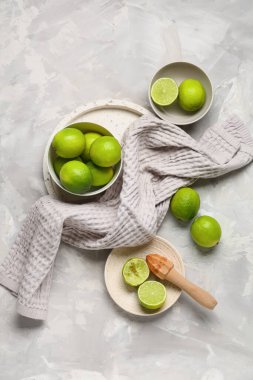 Gri arka planda taze limon dolu kâseler ve tabaklar.